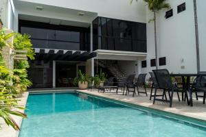 a swimming pool with chairs and a table next to a building at Planaltos Palace Hotel in Goianésia