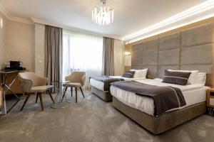a hotel room with two beds and a chandelier at Centralis Hotel in Haskovo