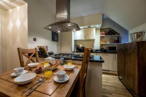 a kitchen with a wooden table with dishes on it at Moat House 8 Harris Apartment in Fort Augustus