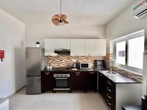 a kitchen with white cabinets and a stainless steel refrigerator at Private Room and Own Kitchen Steps to Beach & Nightlife in Sliema +4 photos