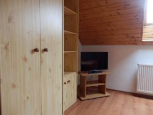 a living room with wooden cabinets and a television at Apartmany Judita Kissová in Veľký Meder