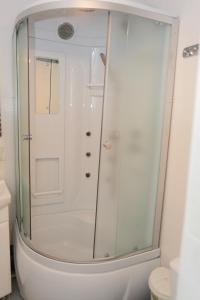 a shower with a glass door in a bathroom at Apartment Studio on Bucuresti 9/1 in Chişinău