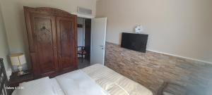 a bedroom with a bed and a tv on a brick wall at AL CORNIOLO in Zerba