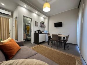 a living room with a couch and a table with chairs at Agorà Connect Space in Brindisi