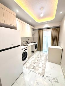 eine Küche mit weißen Geräten und einem großen Fenster in der Unterkunft Bio Residence in Arnavutköy