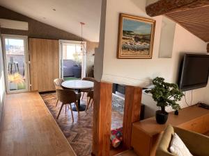 a living room with a table and a tv at Le petit nid Aixois in Aix-en-Provence