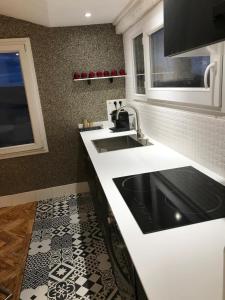 a kitchen with a sink and a black and white tile floor at Le petit nid Aixois in Aix-en-Provence