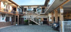 a building with a staircase and a car parked in front at Pousada Anjo Gabriel in Penha