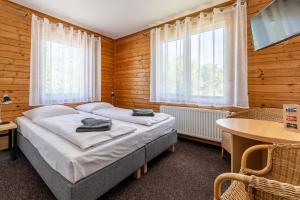 ein Schlafzimmer mit Bett, Tisch und Fenstern in der Unterkunft Pod Orlicą in Duszniki-Zdrój