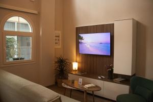 a living room with a flat screen tv on a wall at Chryso Boutique Guesthouse in Chrysoupolis