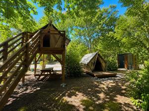 a bird house and a tent in a yard at Camping Le Capdeville in Carcans