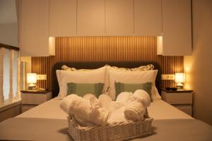 a bedroom with a bed with a basket of towels at Chryso Boutique Guesthouse in Chrysoupolis