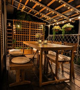 a wooden table and chairs on a patio with lights at 湖畔の詩 BBqが楽しめる隠れ家 琵琶湖徒歩5分 in Takashima