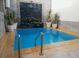 a swimming pool in a room with potted plants at Villa Harmonie - Suite Familiale avec Piscine in Khemisset +3 photos