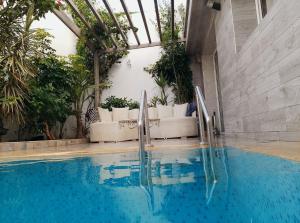 a swimming pool with two chairs and a couch at Villa Harmonie - Suite Familiale avec Piscine in Khemisset