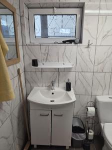a bathroom with a white sink and a window at Poddasze in Zblewo +9 photos
