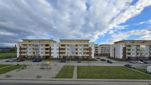 a large building with a parking lot in front of it at Merci Apartament 1,0 in Sibiu