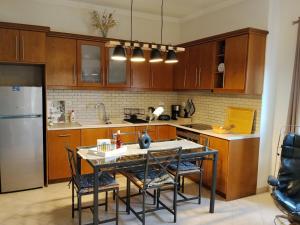 a kitchen with wooden cabinets and a table and chairs at LenasApartment in Valanidorachi +10 photos