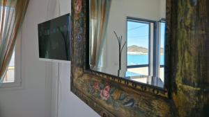 a mirror on a wall with a view of the ocean at Almira Prassa Beach House Kimolos in Prasonísi