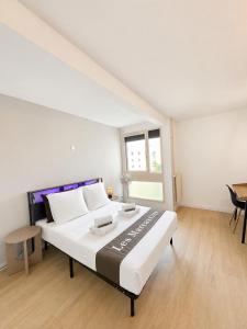 a bedroom with a large white bed in a room at Les Marcassins - Cinéma privé - Alpexpo - 5 Chambres in Échirolles