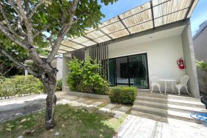 a patio of a house with a tree at Fairtex Residence Pattaya in North Pattaya