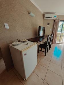 a kitchen with a refrigerator and a table with chairs at Complejo La Yema in Miramar