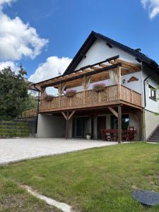 a house with a deck on the side of it at Apartament Malinowe Wzgórze in Krzeszna