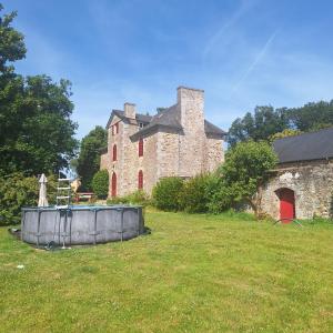 an old stone building with a fence in front of it at Les Roches Blanches Emplacements tente, caravane, camping-car in Guenroc