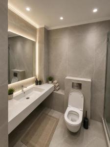 a bathroom with a toilet and a sink at Aqua Hotel in Bishkek +31 photos