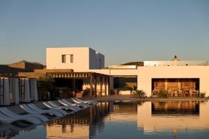 a building with a row of boats in the water at Oroséa Paros - Adults Only, Autograph Collection in Naousa