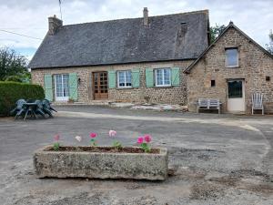 a stone house with pink flowers in front of it at Gîte de la vairie in Larchamp
