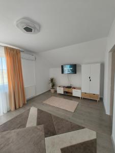 an empty living room with a tv on the wall at Chill Garden House in Satu Mare