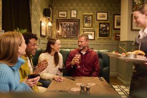 a group of people sitting around a table in a restaurant at The Harrogate Inn - The Inn Collection Group in Harrogate