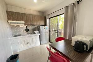 a small kitchen with a table and a refrigerator at Fairtex Residence Pattaya in North Pattaya