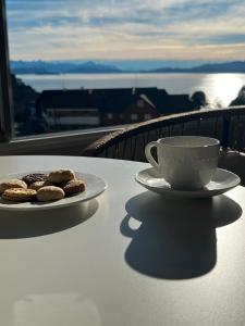 a table with a cup of coffee and cookies on it at Refugio del Sur in San Carlos de Bariloche +3 photos