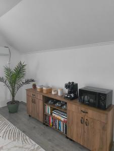 a wooden book shelf with a microwave on top of it at Chill Garden House in Satu Mare