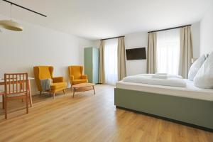 a bedroom with a bed and two chairs and a table at Kaffeegarten Am Mühlwerder in Halle an der Saale