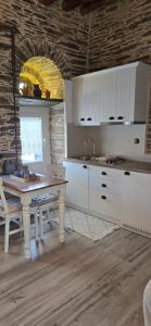 a kitchen with white cabinets and a table with a sink at The Kamaraki Project in Kórthion