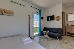 a bedroom with a bed and a couch and a window at Almond Beachfront Resort - kalyves Halkidiki in Kalives Poligirou