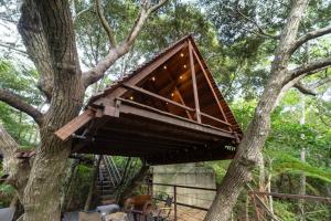 a tree house built in a tree at Yambaru Wild Treehouse Kidzy in Takee