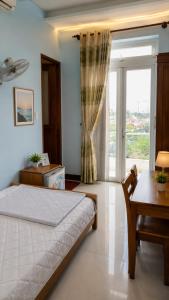 a bedroom with a bed and a table and a window at Motel Đại Phát Đạt in Cù Lao Tâu