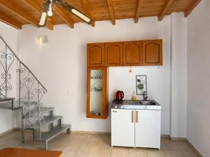a kitchen with white cabinets and a staircase at Bella Casa Lydia - Peaceful Retreat in Rhodes in Rhodes Town