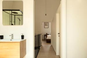 a hallway of a house with a sink and a mirror at Unique renovated chapel in Temse +10 photos