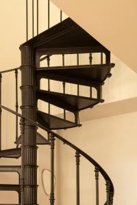 a black spiral staircase in a house at Unique renovated chapel in Temse
