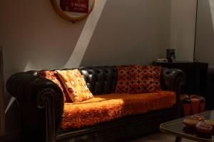 a black leather couch with two pillows on it at Unique renovated chapel in Temse
