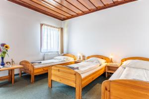 a room with four beds and two tables at Pensjonat Stokłos in Duszniki Zdrój