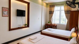 a hotel room with two beds and a mirror at Motel Đại Phát Đạt in Cù Lao Tâu