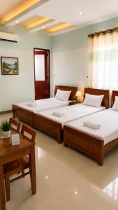a bedroom with two beds and a table at Motel Đại Phát Đạt in Cù Lao Tâu