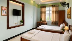 a hotel room with two beds and a mirror at Motel Đại Phát Đạt in Cù Lao Tâu