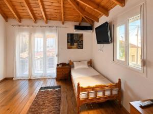 a bedroom with a bed and a tv on the wall at Bella Casa Lydia - Peaceful Retreat in Rhodes in Rhodes Town